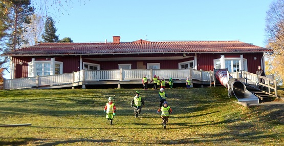 Bild på Hedlunda förskola med barn som springer ner för backen