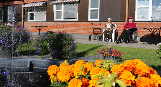 Bild på damer som solar och rollator samt rullstol