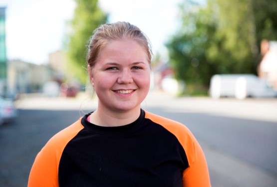 En kvinna står i kommunhusets trappuppgång