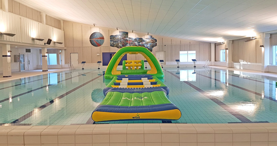 Bild på stora bassängen i simhallen med en lekborg i vattnet.