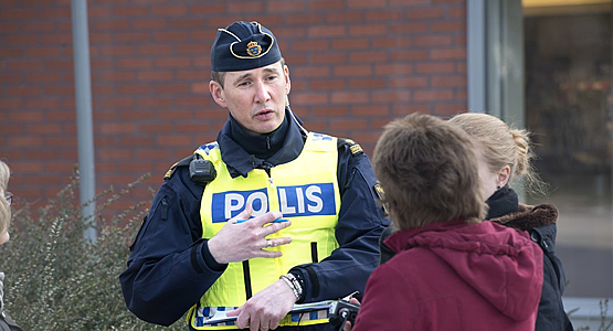 Uniformerad polis samtalar med medborgare