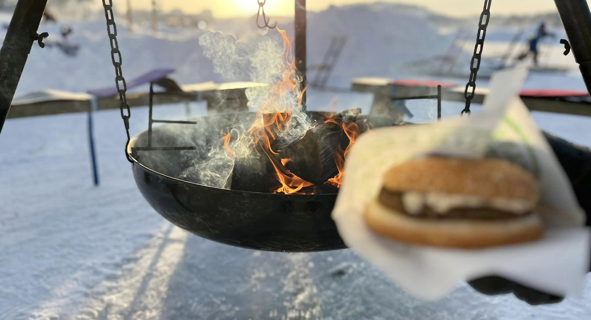 Bild på matlagning över eld, vinter på isen i Lycksele. 