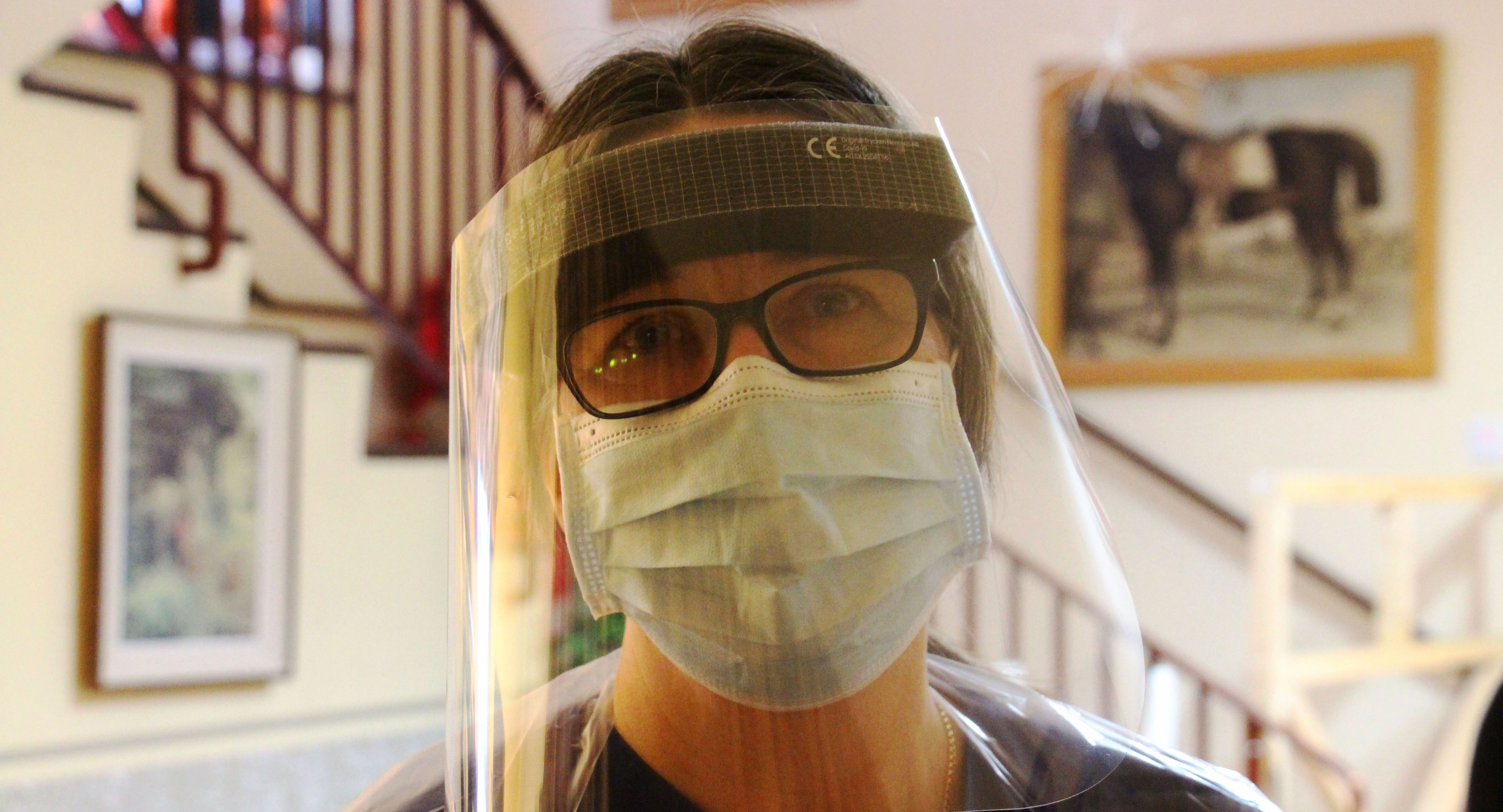 Bild på kvinna med munskydd och visir