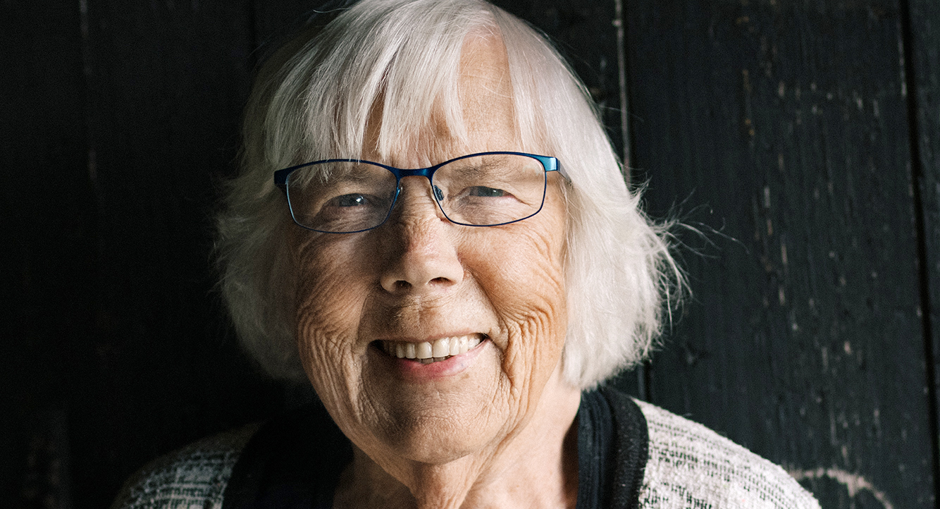 Bild på äldre kvinna som ler mot kameran