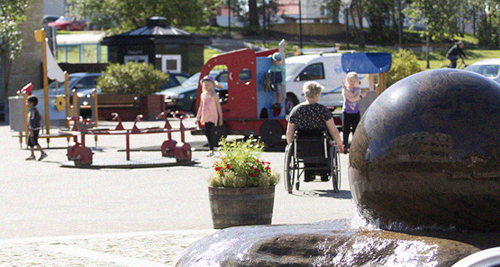 Torget i Lycksele, rullstolsburen person, barn som leker