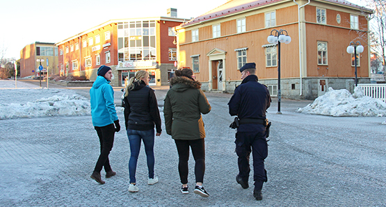 Fyra människor som promernerar över torget i Lycksele