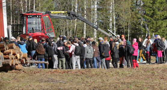 Bild på elever i samling vid skogsfordon