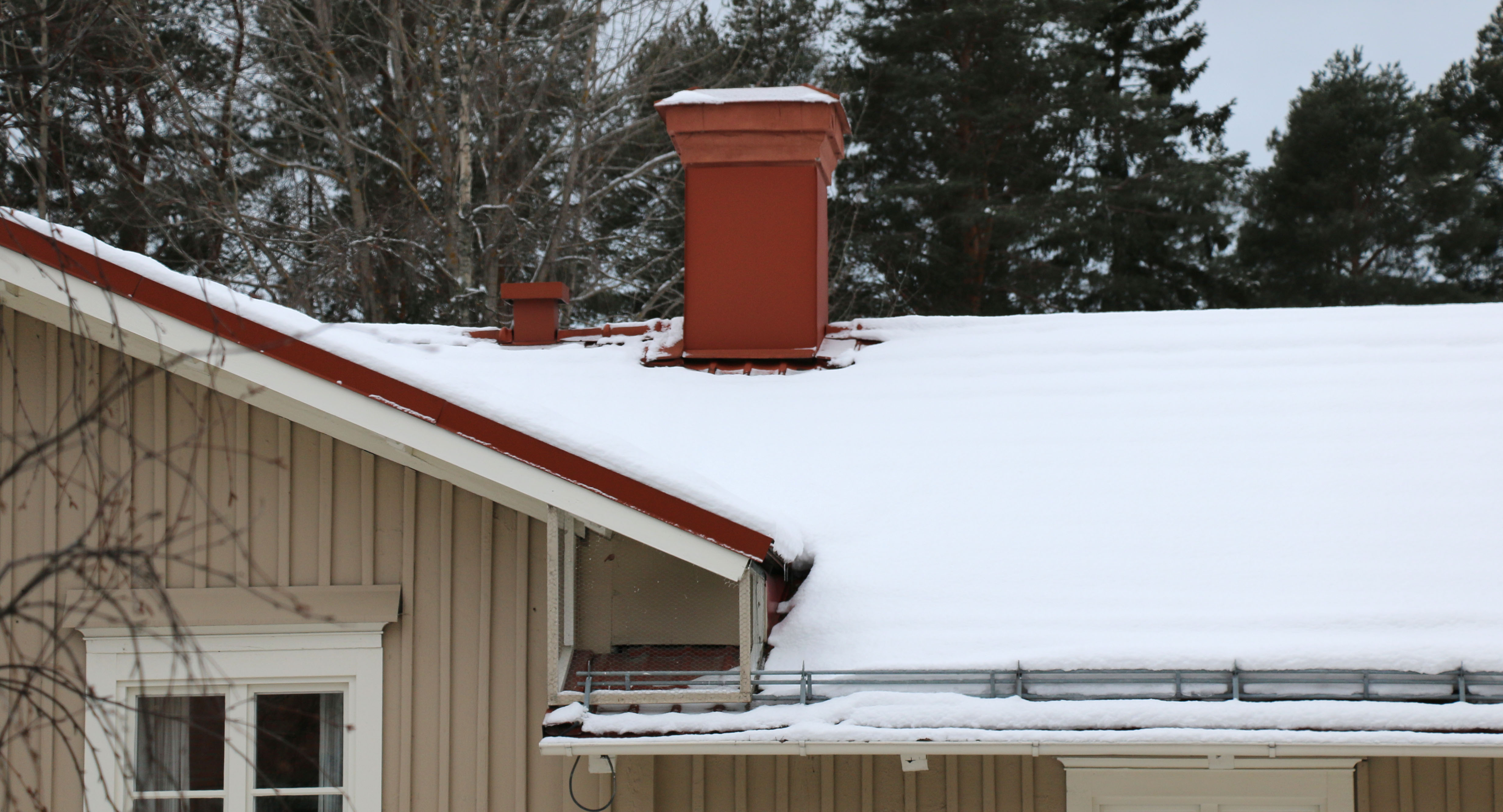 Bild på skorsten och en hustak med snö